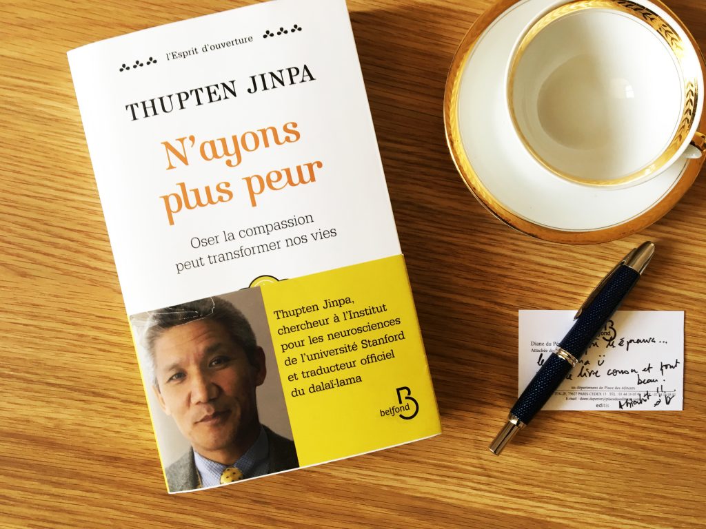 la couverture du livre de Thupten Jinpa, N'ayons plus peur, posé sur une table basse à côté d'une tasse à thé et d'un stylo plume