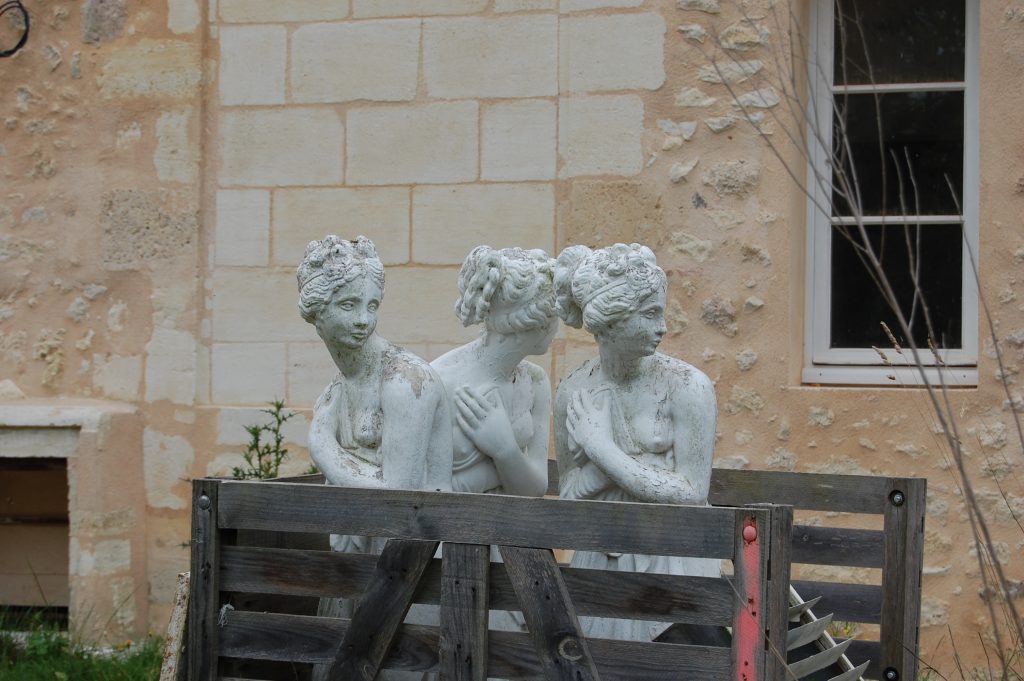 trois statues romaines représenatnt des femmes sont stockées dans une caisse en bois en attednat d'être re^macées dans le parc d'un château.