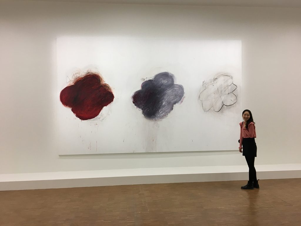 Une jeune femme asiatique devant une grande toile du peintre Cy Twombly durant l'exposition à beaubourg en 2017. Le sourire de la jeune femme amène une légèreté joyeuse à l'image.