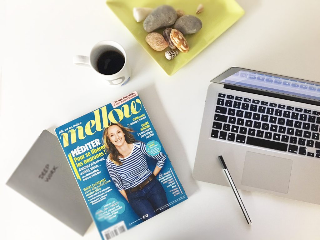 Le magazine Mellow (avec en couverture l'actrice Audrey Lamy) est posé sur une table, à côté d'un mug de café et d'un ordinateur portable.