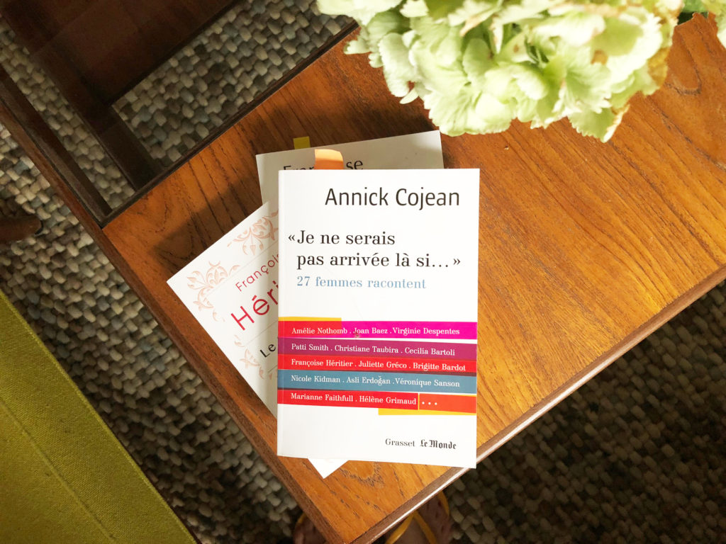 Le livre de Anncik Cojean est posé sur deux autre slivres, sur une table basse en teck. Une boule de fleur d'hortensia apparaît en amorce de la photo