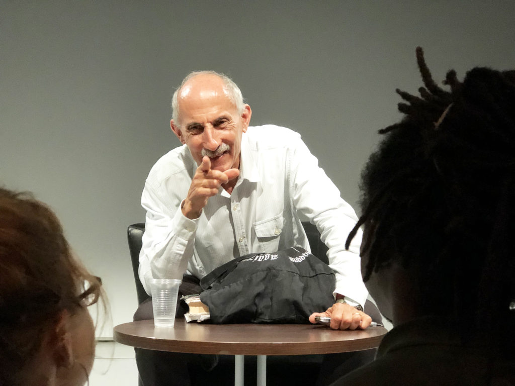 On voit Jack Kornfield souriant au premier rang de son auditoire lors de sa conférence à Paris en juillet 2018