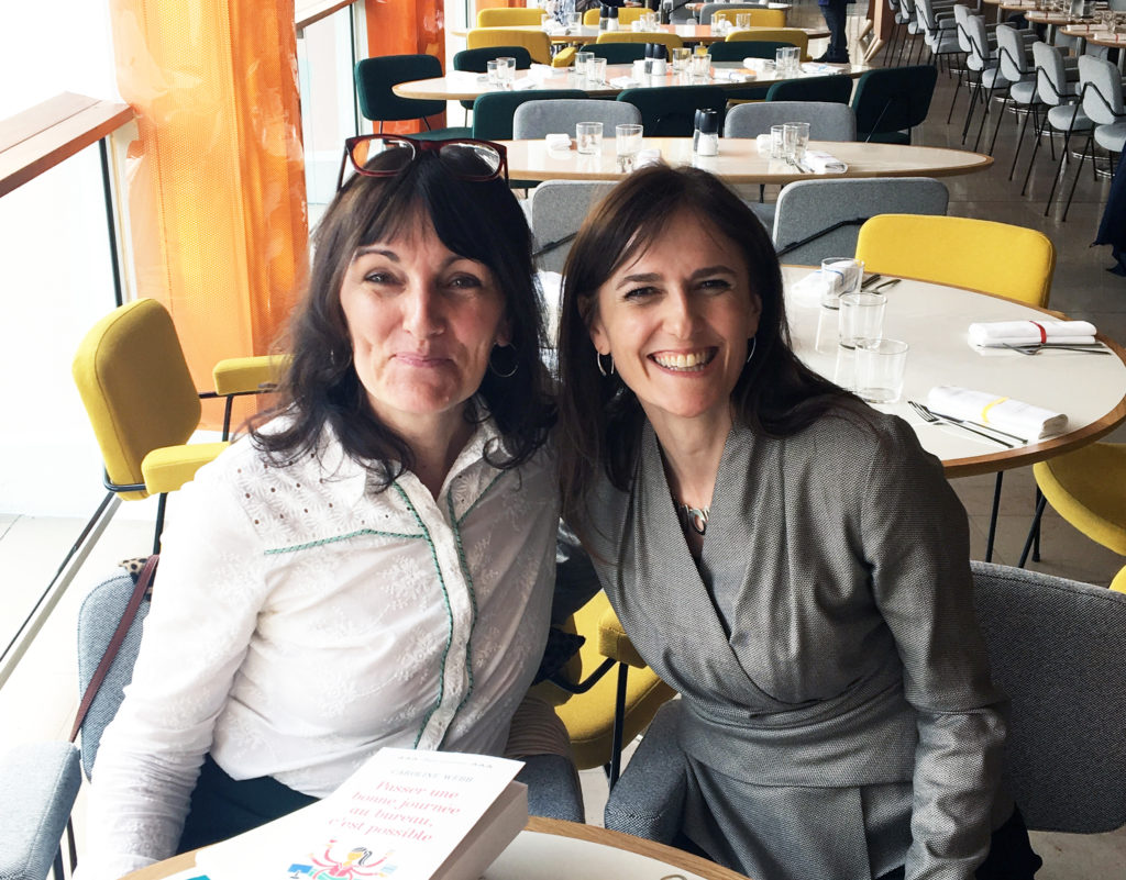 Marie-Laurence et Caroloine, assises côte à côte dans un café, regardent l'objectif en souriant.