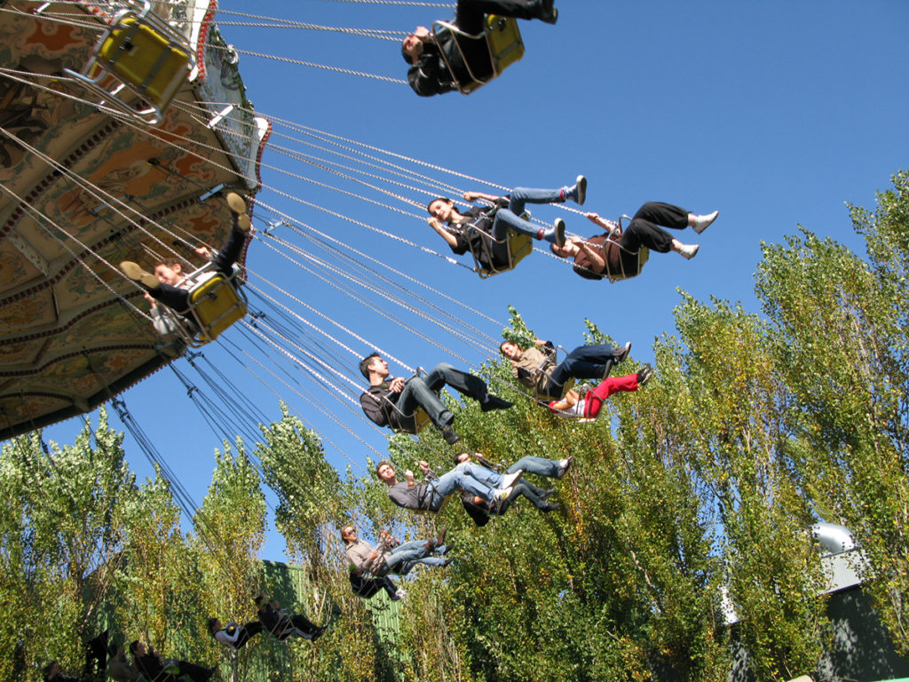 des enfants sur un manège sur fond de ciel bleu