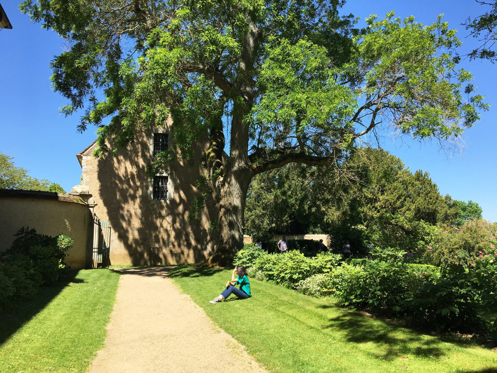 Se repemer - Une jeune femme est assise au soleil, dans les jolis jardins de la Maison de Georges Sand