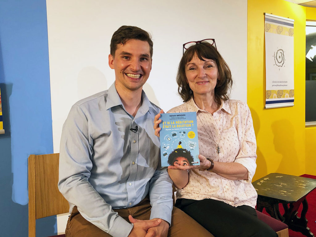 Selfie joyeux de Mathieu Brégégère à gauche et Marie-Laurence Cattoire à droite, assis côte à côte. Marie-Laurence tient le livre de Mathieu "Et si la méditation était la solution ? Répondre aux problèmes des adolescents. Ils regardent tous deux la caméra en souriant avant de démarrer la conférence sur les adolescents.